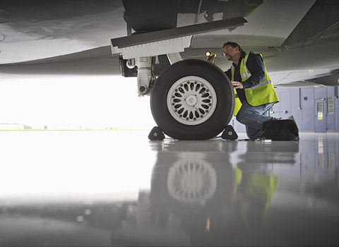London aviation photograph of inspecting the landing gear of an aeroplane
