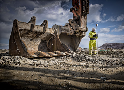 Surveyor with excavator buckets on a site in Essex