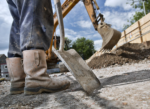 Construction worker photographed leaning on shovel