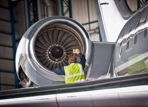 Worker checking an engine on a plane at Stansted Airport, Essex