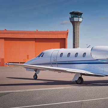 Small private airplane with a control tower in the background