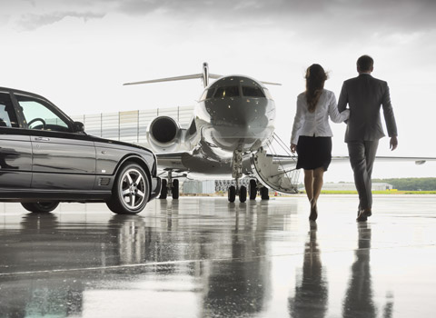 Couple approching an aeroplane for a private flight