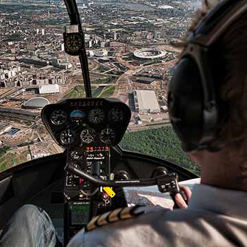 View over the pilots shoulder in a helicopter as it is flying over the Olympic Park in Stratford.