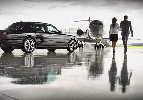 A couple walking towards a private jet at an airport in Essex