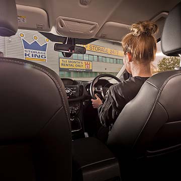 Woman driving up to a large storage facility in Colchester, Essex