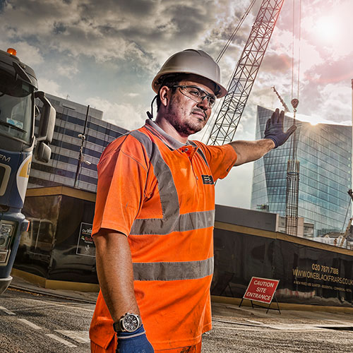 A Banksman directing traffic at a London construction site photographed for the Considerate Constructors Scheme.