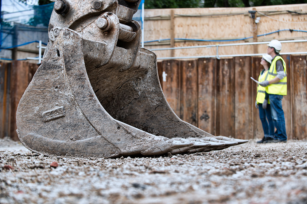 People on a construction site with excavator