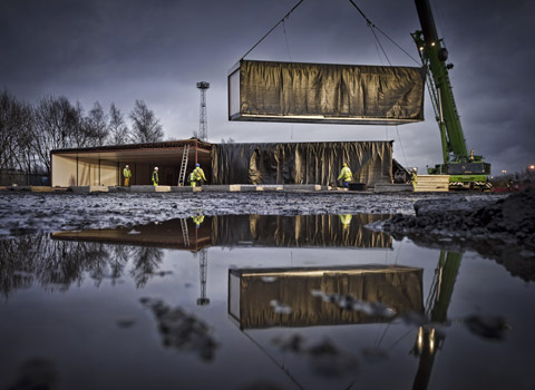 Portable building being craned in on a construction site in Manchester