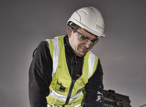 Roofer using a blowtorch on a roof at a construction site in West London