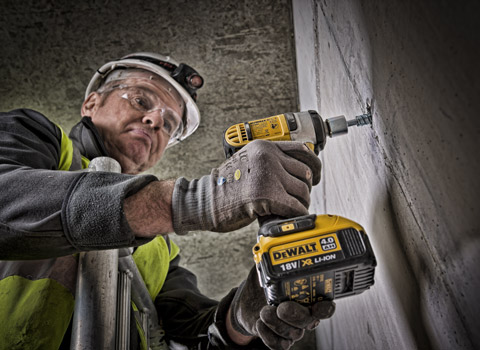 Construction worker on a building site using a deWalt power tool