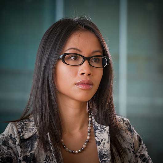 Young female office worker with a window behind her photographed for a website