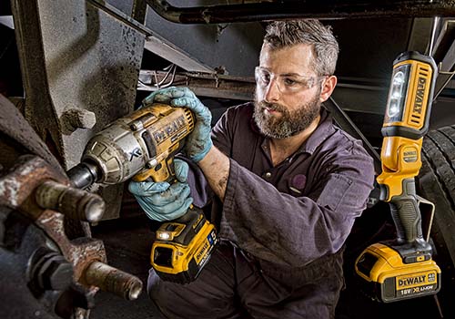 A mechanic working on the wheel of a lorry for a major logistics company.