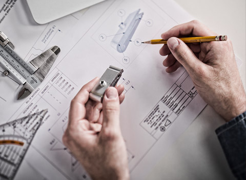 Worker checking a product with a blueprint