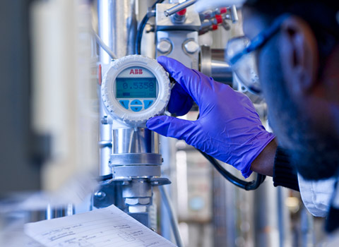 Worker checking a dial in a chemmical plant at Imperial College, London