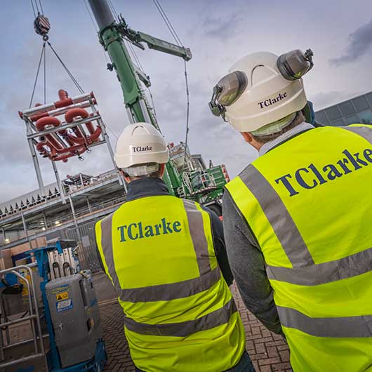 Engineers inspecting a crane lift of mechanicl services unit onto the roof of a data center in Slough