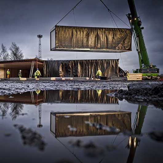 An off-site constructed building being craned into positionn at night on a Birmingham construction site