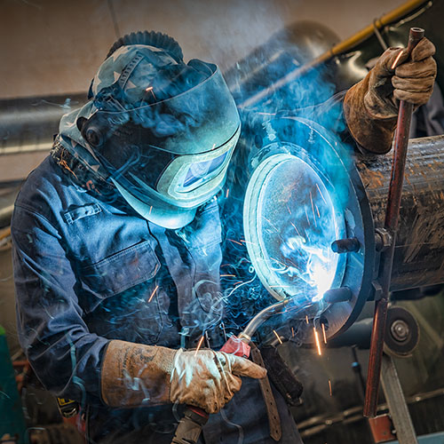 Photograph of a welder in an industrial site in London