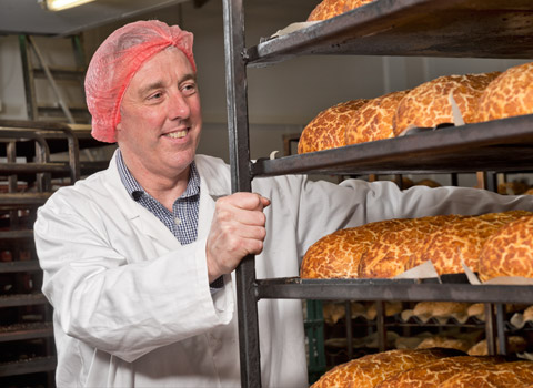 Baker with loaves of bread for a magazine