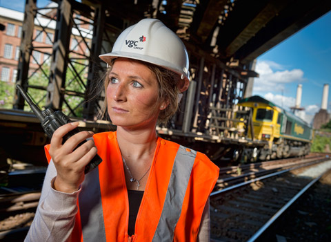 Female worker on the railway using a radio