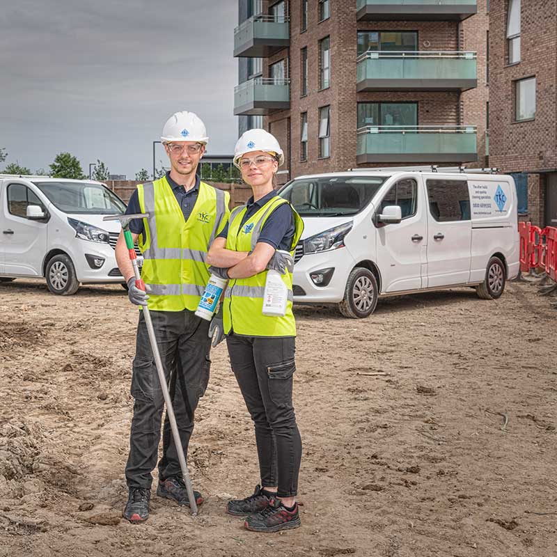 Industrial cleaners posing in front of their vans on a construction site in Woolich, London