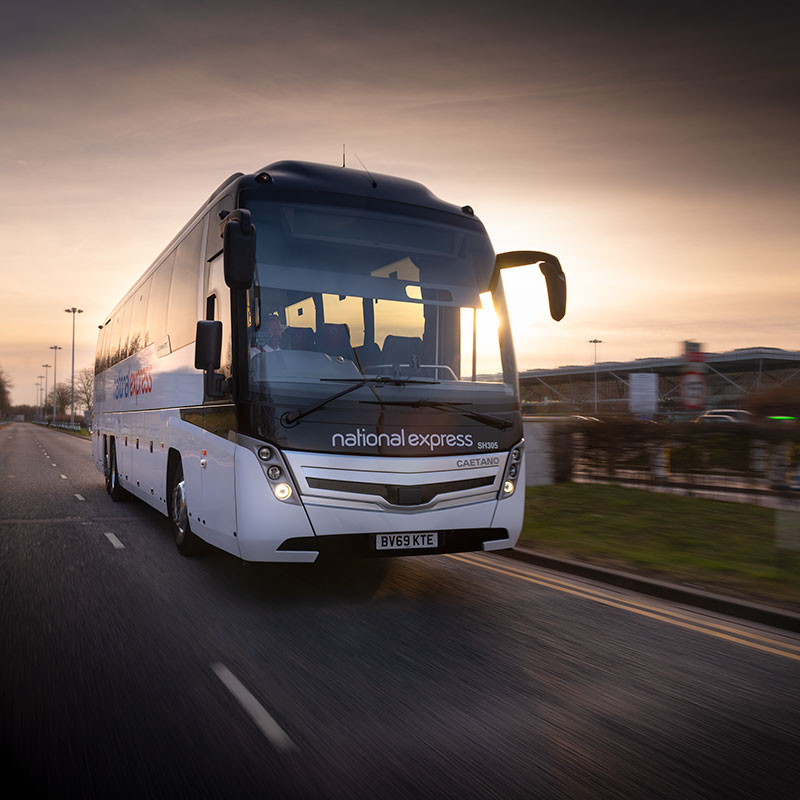 Tracking shot of a coach being driven near Stansted Airport at sunset